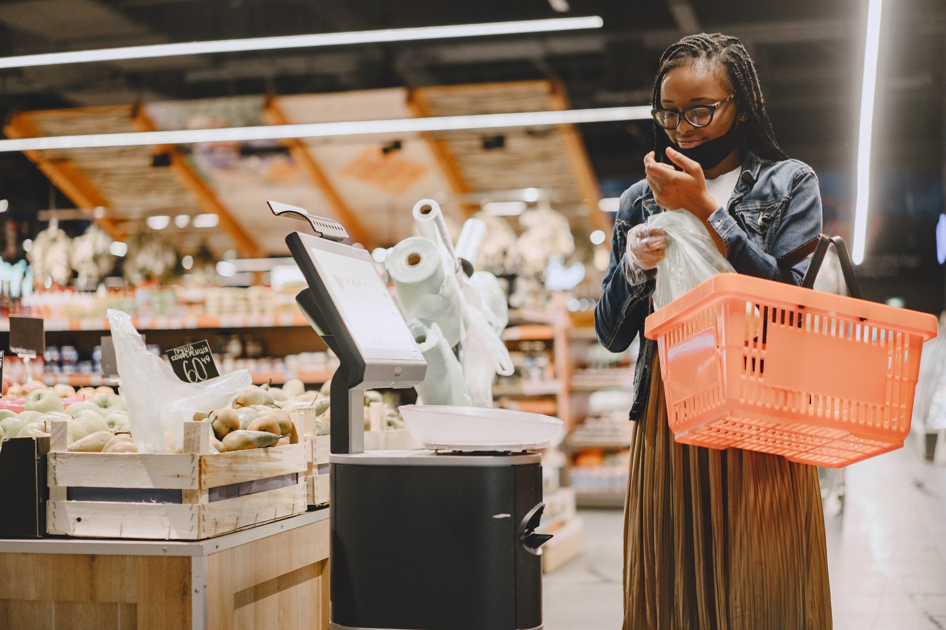 Une femme fait des courses dans un supermarché, vérifiant les articles avec un panier à la main.
